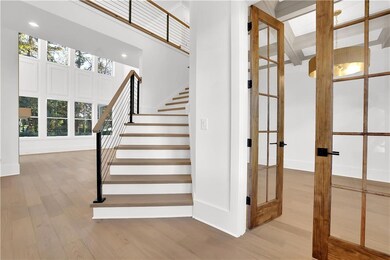 Staircase with wood finished floors, french doors, and recessed lighting