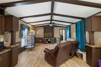 Living room with a ceiling fan, light wood-type fl