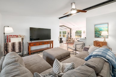 Living room featuring a ceiling fan and baseboards