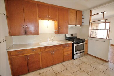 Kitchen with light tile patterned floors, sink, ba