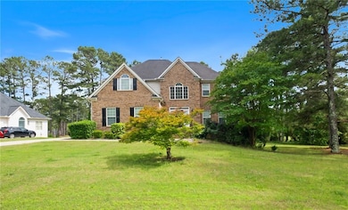 View of front of home featuring a garage, concrete driveway, brick siding, and a front lawn