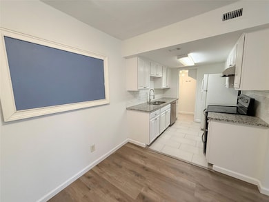 Kitchen with under cabinet range hood, appliances