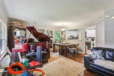 Living area with wood finished floors and crown molding