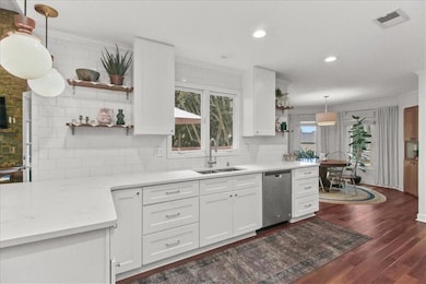Kitchen with hanging light fixtures, open shelves, backsplash, dark wood-style flooring, and ornamental molding