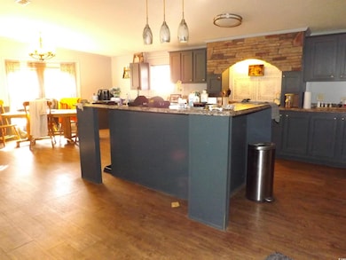 Kitchen featuring an island with sink, pendant lig