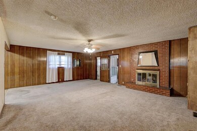 Unfurnished living room with a fireplace, wood wal