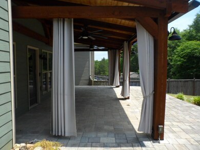 View of patio with ceiling fan and fence