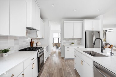 kitchen featuring stainless steel appliances, white cabinets, decorative backsplash, light stone countertops, and recessed lighting