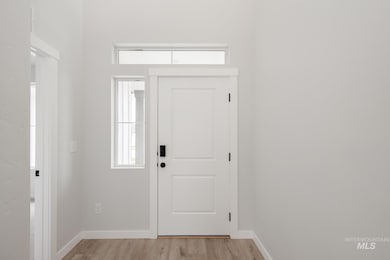 Entryway with light wood-style floors and baseboards