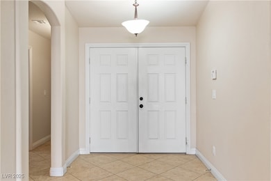 Foyer entrance with arched walkways and light tile patterned floors