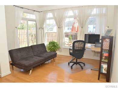 Airy sunroom with hardwood floors transomed window