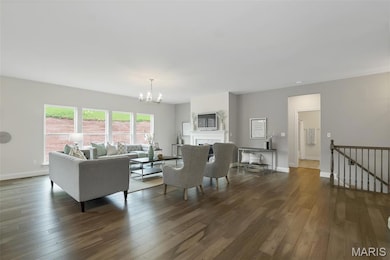 Living room featuring a chandelier, wood finished floors, and a fireplace