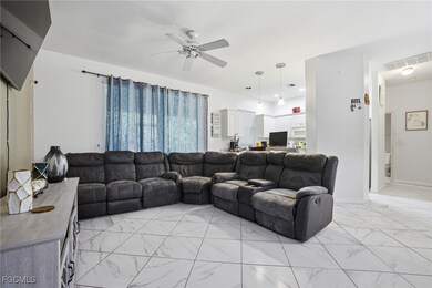 Living area with light marble finish floors and a ceiling fan