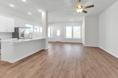 Kitchen island open to living area with view of ba