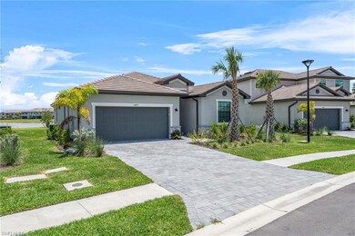 Ranch-style home with stucco siding, a garage, a front lawn, and decorative driveway
