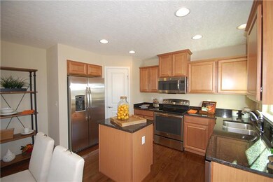 Kitchen with walk in pantry has SS appliances and DARK Maple Espresso kitchen cabinets and gorgeous granite - photo shown is not actually the home for sale.