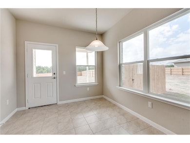 Unfurnished dining area featuring light tile patterned floors and baseboards