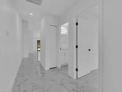 Corridor featuring light marble finish flooring, baseboards, and recessed lighting