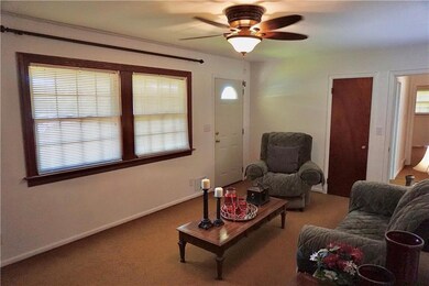 Living area with carpet, a ceiling fan, and healthy amount of natural light