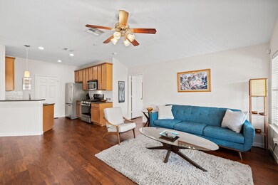 Living area with ceiling fan, dark wood-type floo