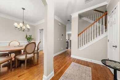 Dining room featuring light wood-style flooring, crown molding, stairway, and a chandelier
