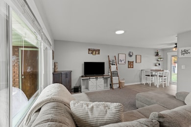Living area with a ceiling fan and carpet