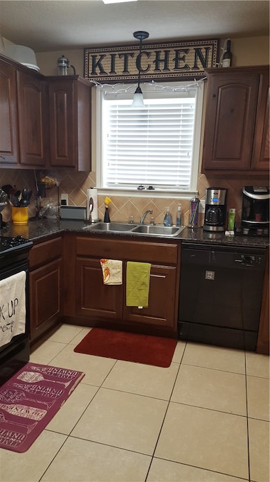 Kitchen with range, light tile patterned flooring,