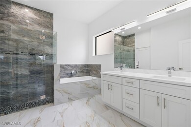Bathroom with a stall shower, double vanity, a gar