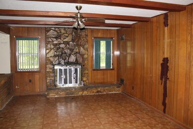 Unfurnished living room featuring a ceiling fan, w