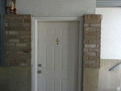 Entrance to property featuring brick siding and stucco siding