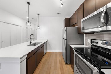 Kitchen with a peninsula, light wood-style flooring, a sink, stainless steel appliances, and backsplash
