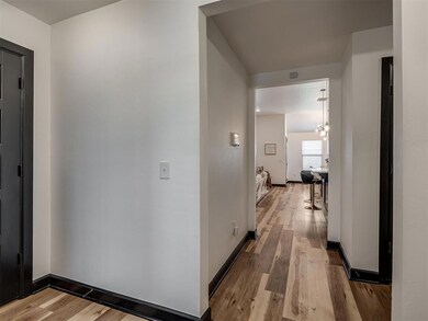 Hall with light wood-style floors and baseboards