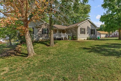 Back of house featuring a wooden deck and a lawn