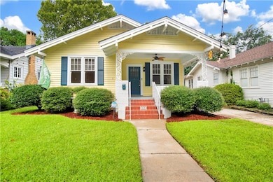 View of front of home with a ceiling fan and a front yard