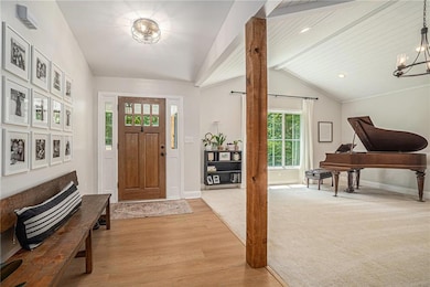 Foyer with a chandelier, light wood-style floors, and baseboards
