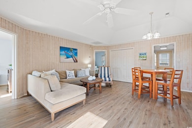 Living room featuring vaulted ceiling, ceiling fan