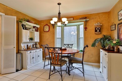 Tiled dining room featuring a designer light fixture.