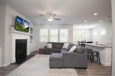 Living area with visible vents, baseboards, wood f
