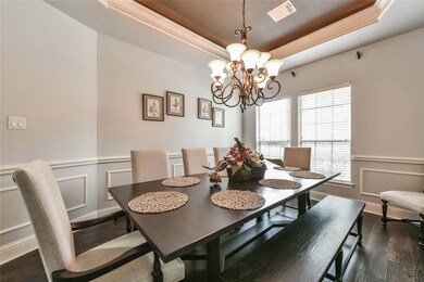 formal dining with details galore -recessed ceiling, chair rails and wood floors complete the look