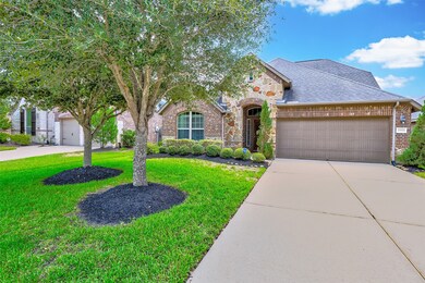 A landscaped pathway leads to the front door framed with transom windows that allow for natural light to pour into the front entrance.