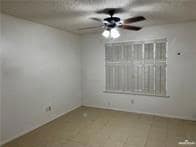 Unfurnished room featuring a ceiling fan and baseboards