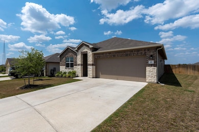 View of front facade featuring stone siding, a garage, driveway, and roof with shingles