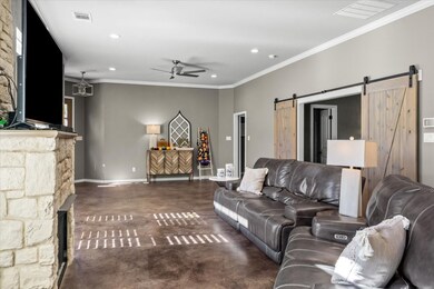 Living area with ornamental molding, finished concrete flooring, a ceiling fan, a fireplace, and recessed lighting