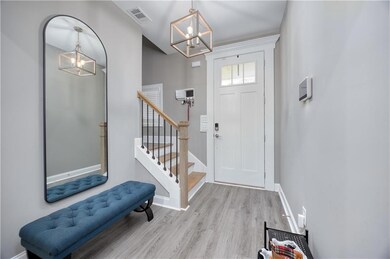 Foyer featuring a chandelier, light wood finished floors, and stairway