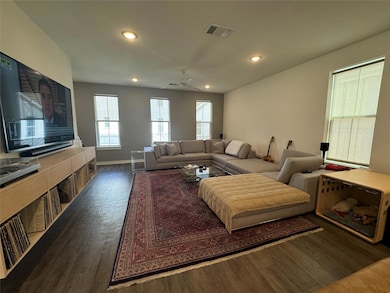 Living area with dark wood-style flooring, recess