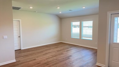Spare room featuring wood finished floors, recessed lighting, and vaulted ceiling