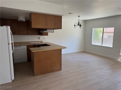 Kitchen featuring white appliances, light wood-sty