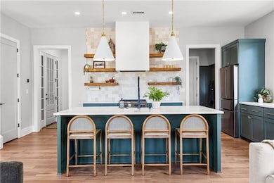 Kitchen featuring visible vents, a center island w
