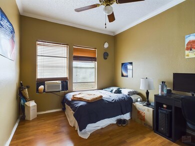 Bedroom featuring wood finished floors, crown mol