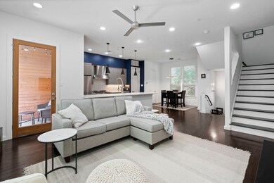 Living area featuring wood finished floors, a ceiling fan, recessed lighting, and stairs